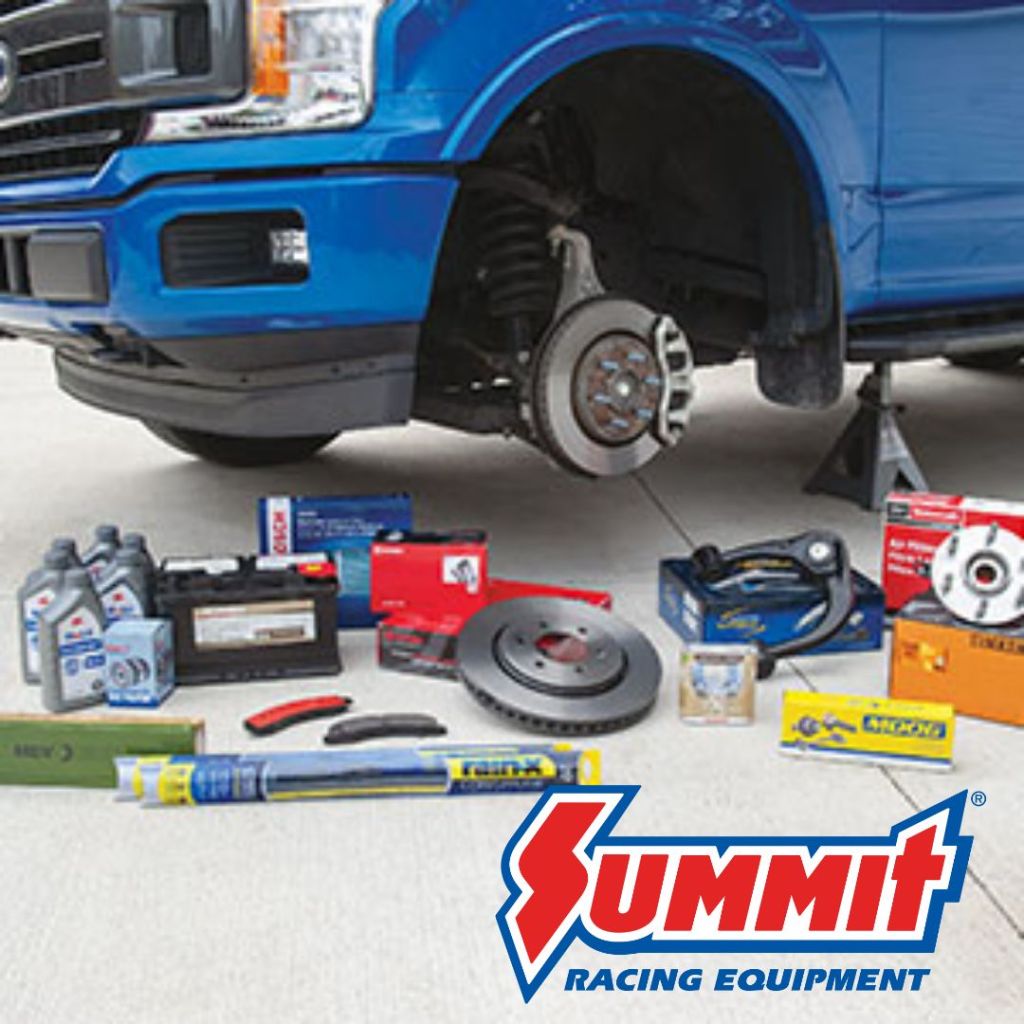 A blue truck with one wheel removed, showcasing various automotive tools and parts arranged on the ground, including oil, a battery, brake components, and a logo for Summit Racing Equipment.